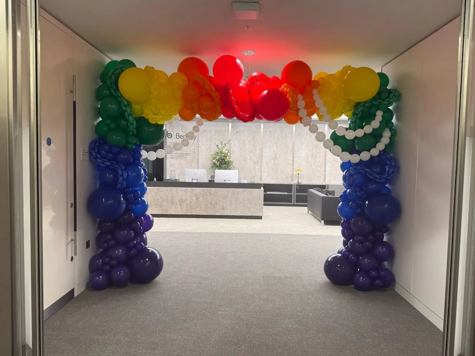 Rainbow organic balloon arch installed for a Pride event